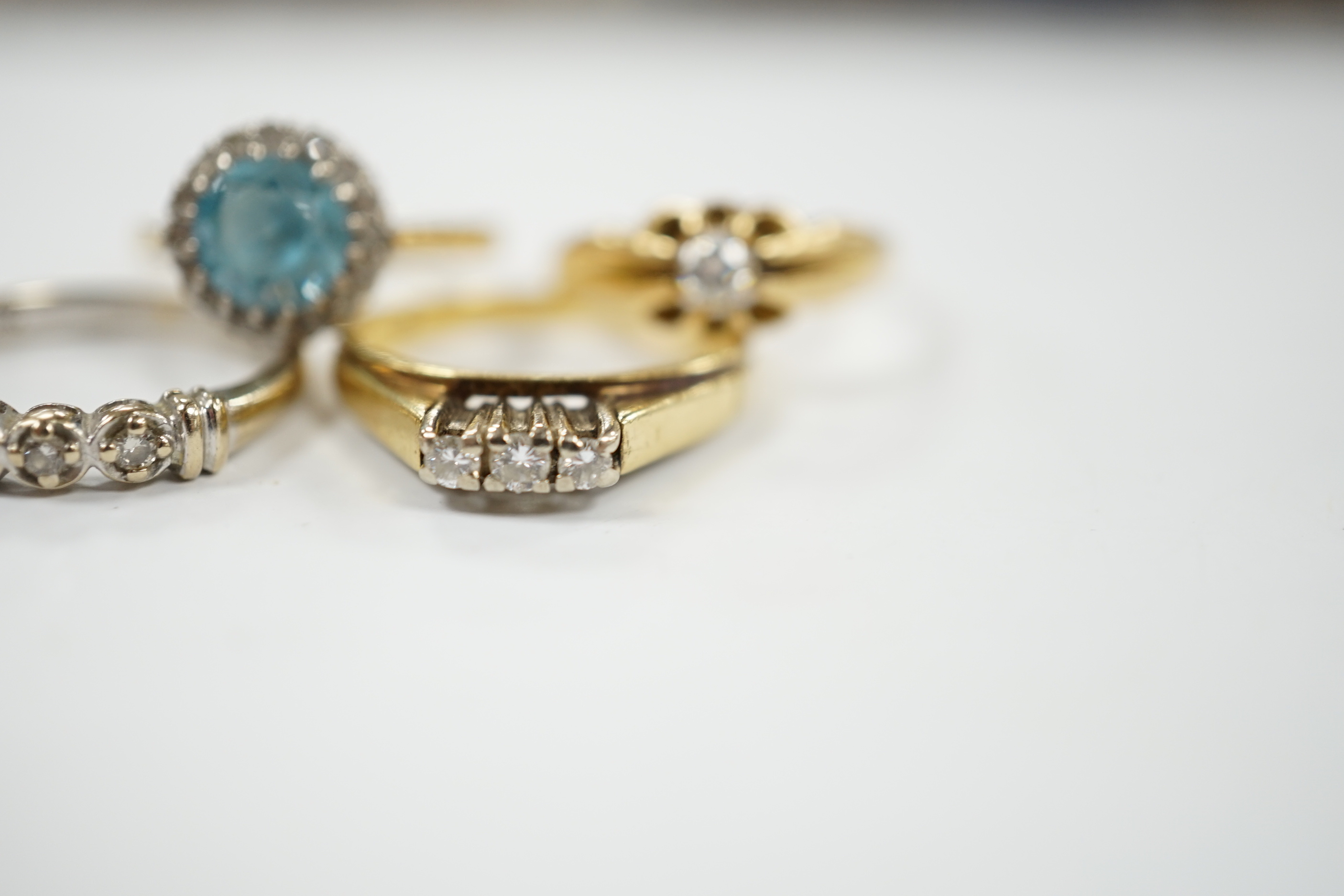 Three assorted 18ct and gem set dress rings, including blue zircon and diamond chip and claw set solitaire and one other yellow metal and gem set ring, gross weight 12.6 grams.